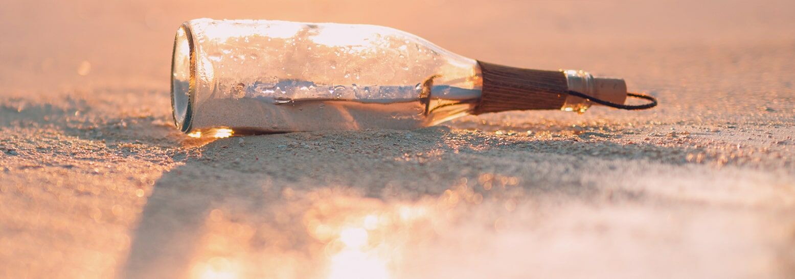 Flaschenpost, die am Strand liegt